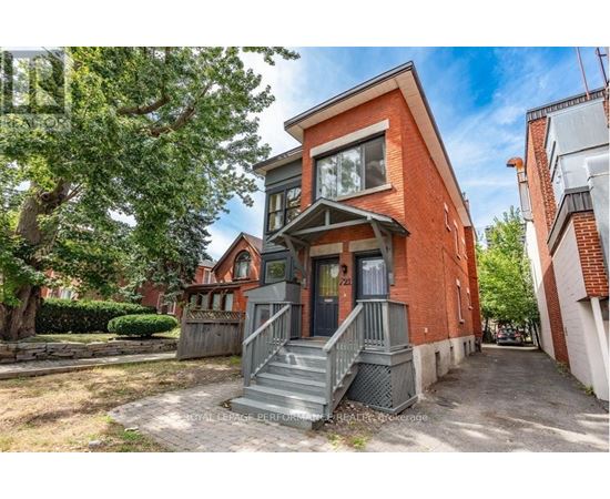 A red brick house with a grey front porch and stairs.