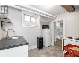 A small kitchen with a sink, refrigerator, and a stove.