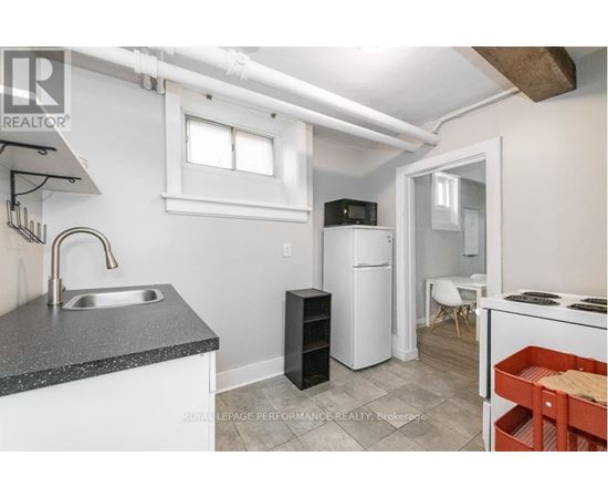 A small kitchen with a sink, refrigerator, and a stove.