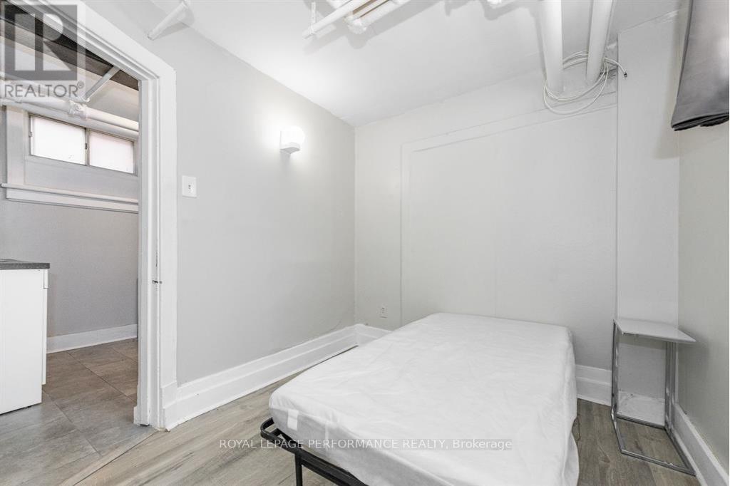 A bedroom with a bed, nightstand, and window.