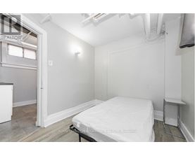 A bedroom with a bed, nightstand, and window.