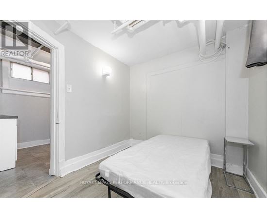 A bedroom with a bed, nightstand, and window.