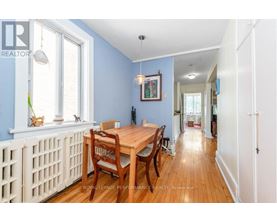 A dining room with a wooden table and chairs.
