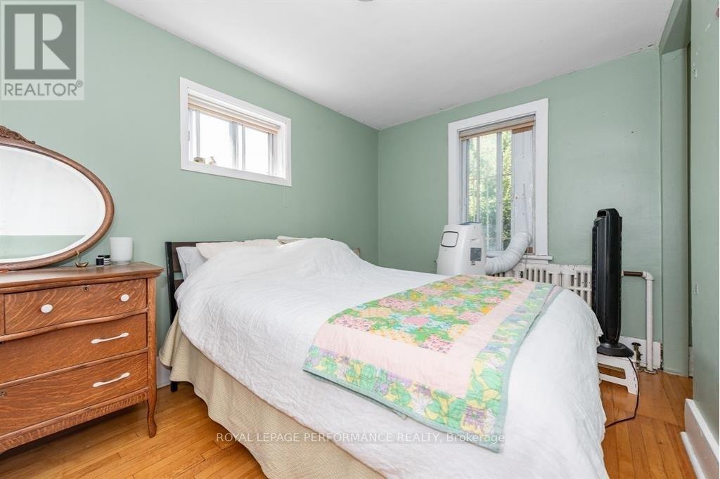 A bedroom with a bed, dresser, and window.