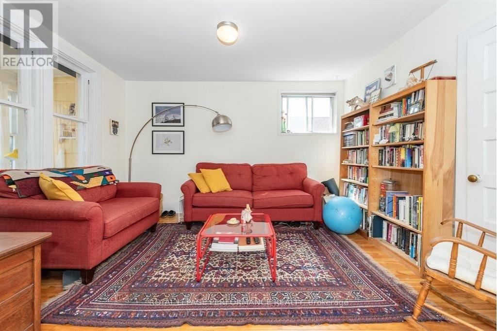 A living room with red couches and a rug.