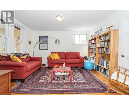A living room with red couches and a rug.