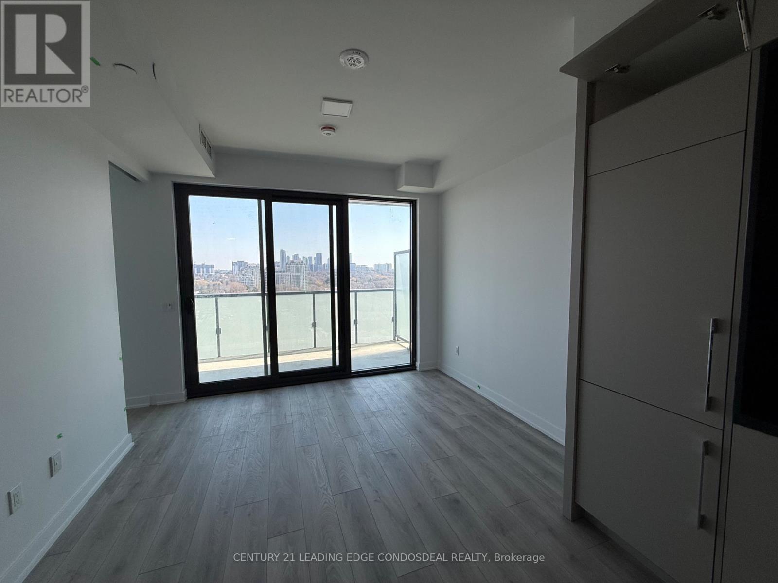 A spacious room with a view of the city through large windows.