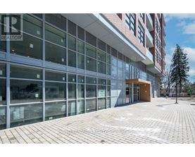 A modern building with glass windows and a brick walkway in front.