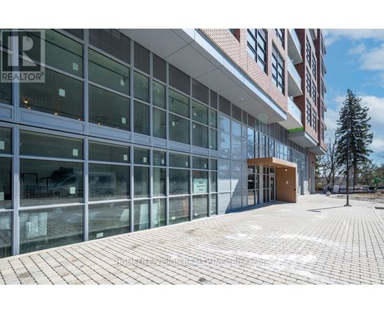 A modern building with glass windows and a brick walkway in front.