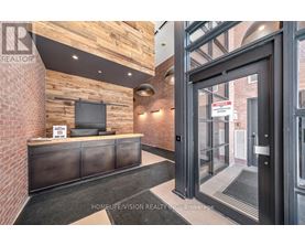 A realtor's office with a brick wall and a black reception desk.