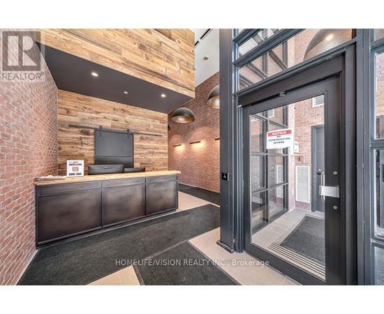 A realtor's office with a brick wall and a black reception desk.
