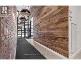 A hallway with a wooden wall and a brick wall on the side.