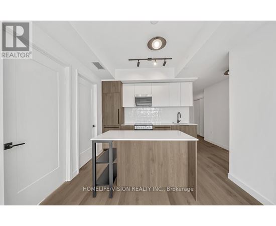 A modern kitchen with white cabinets and a wooden island.