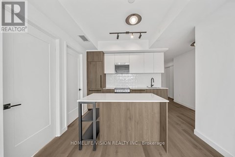 A modern kitchen with white cabinets and a wooden island.