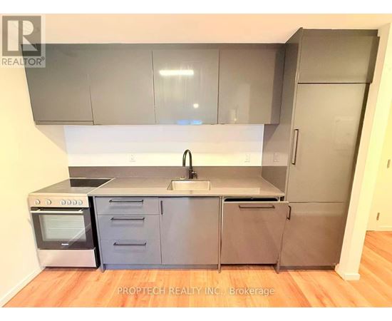 A kitchen with a stainless steel refrigerator, oven, and sink.