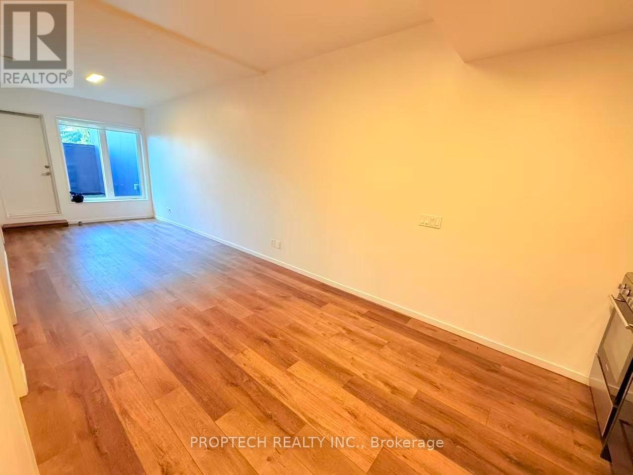 A room with wooden flooring and a window.