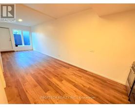 A room with wooden flooring and a window.