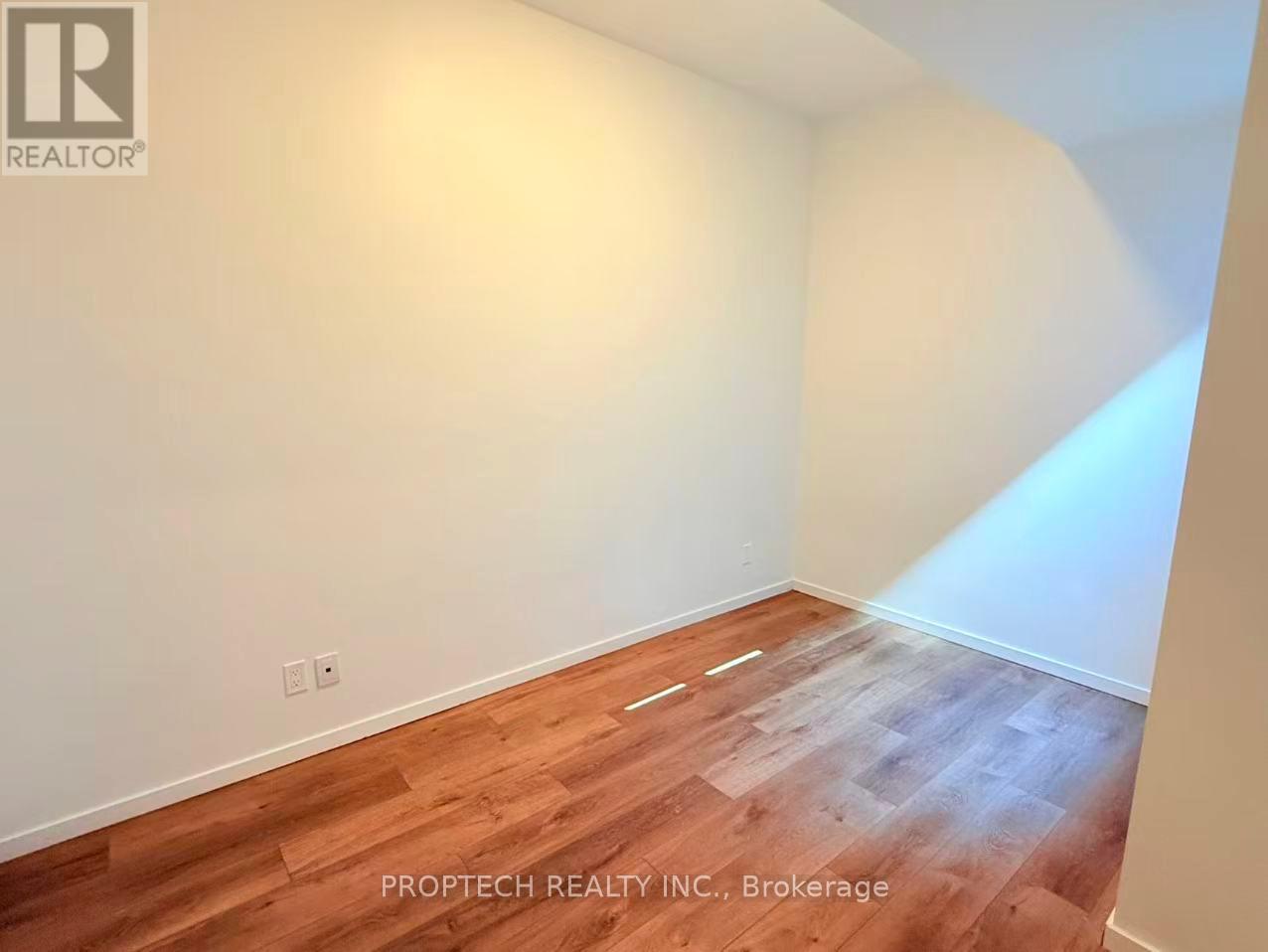 A room with wooden flooring and white walls.