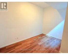 A room with wooden flooring and white walls.