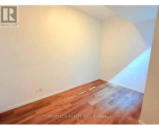 A room with wooden flooring and white walls.