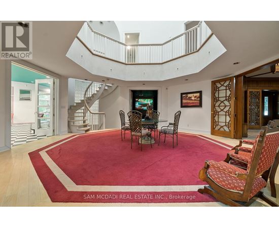A living room with a red carpet and a spiral staircase.