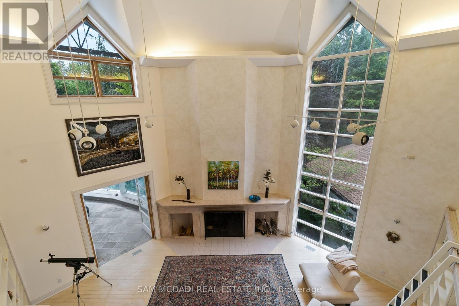 A well-lit, spacious room with a large window and a view of a garden outside.