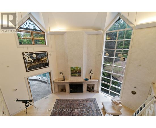 A well-lit, spacious room with a large window and a view of a garden outside.
