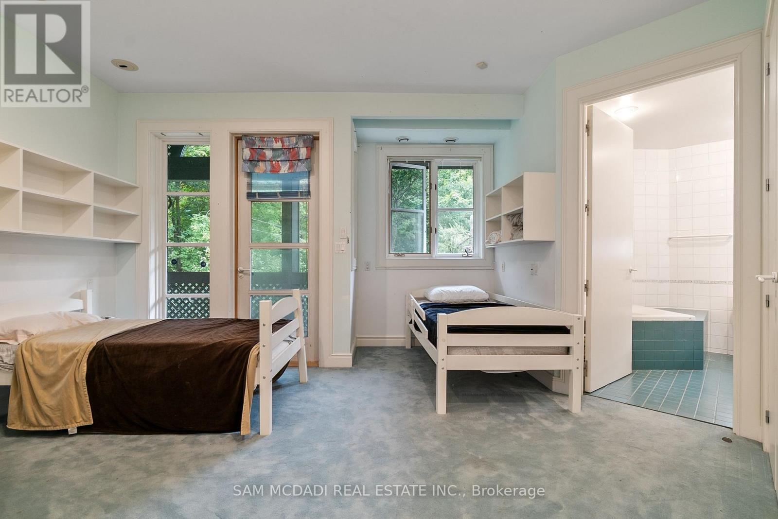 A bedroom with two beds and a window.
