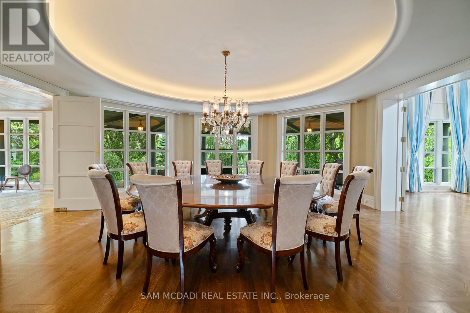 A dining room with a round table and chairs.
