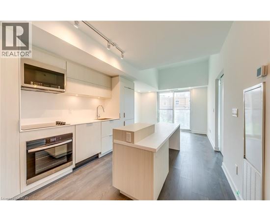 A modern kitchen with white cabinets and stainless steel appliances.