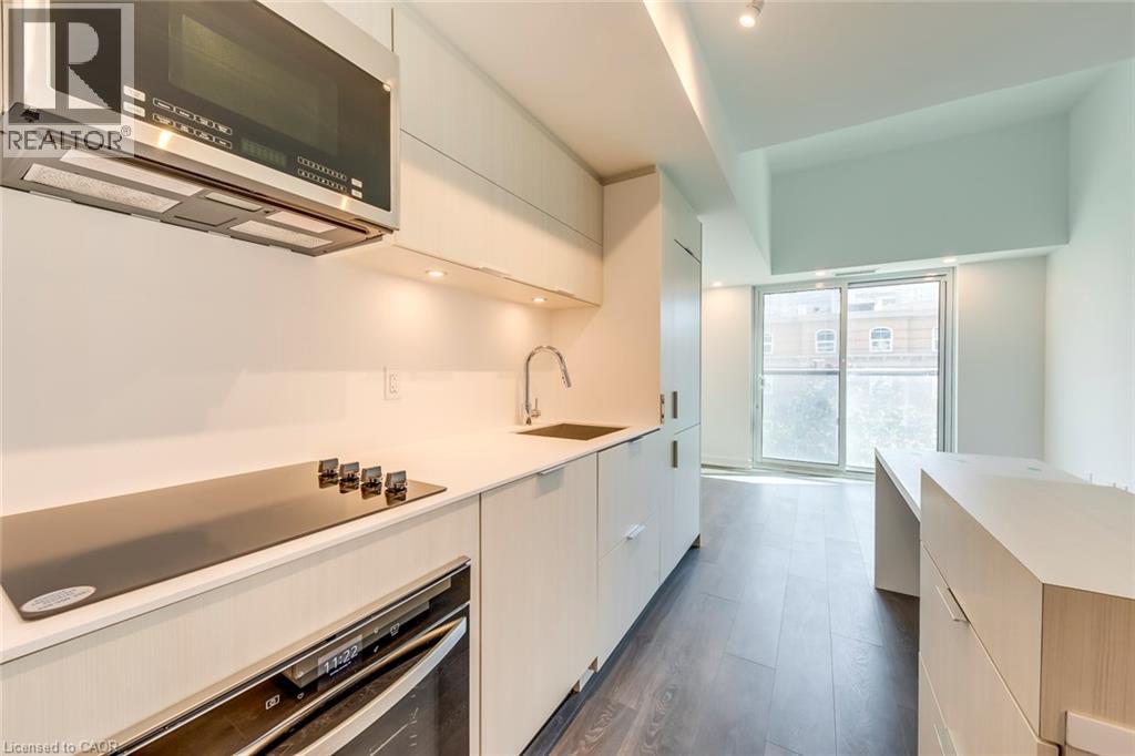 A modern kitchen with white cabinets and stainless steel appliances.