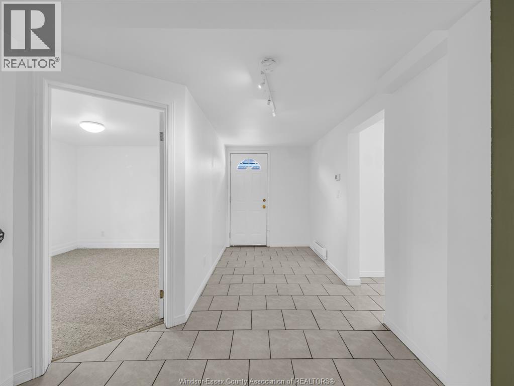 A hallway with a carpeted floor and white walls.