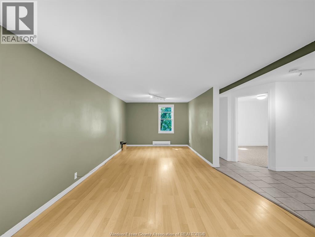 A room with wooden flooring and white walls.