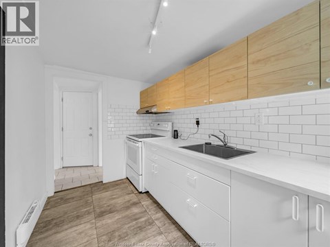 A kitchen with white cabinets and a white dishwasher.