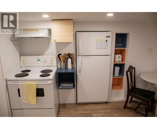 A small kitchen with a white fridge and a white stove.
