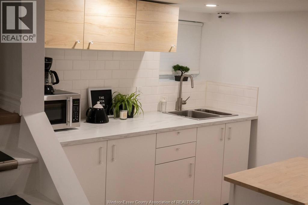 A kitchen with white cabinets and a wooden counter.