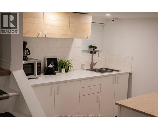 A kitchen with white cabinets and a wooden counter.