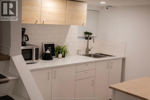 A kitchen with white cabinets and a wooden counter.