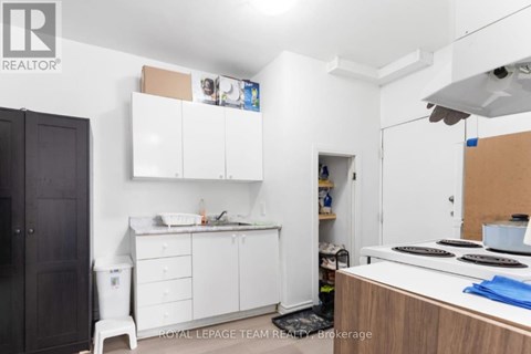 A kitchen with white cabinets and a wooden counter.