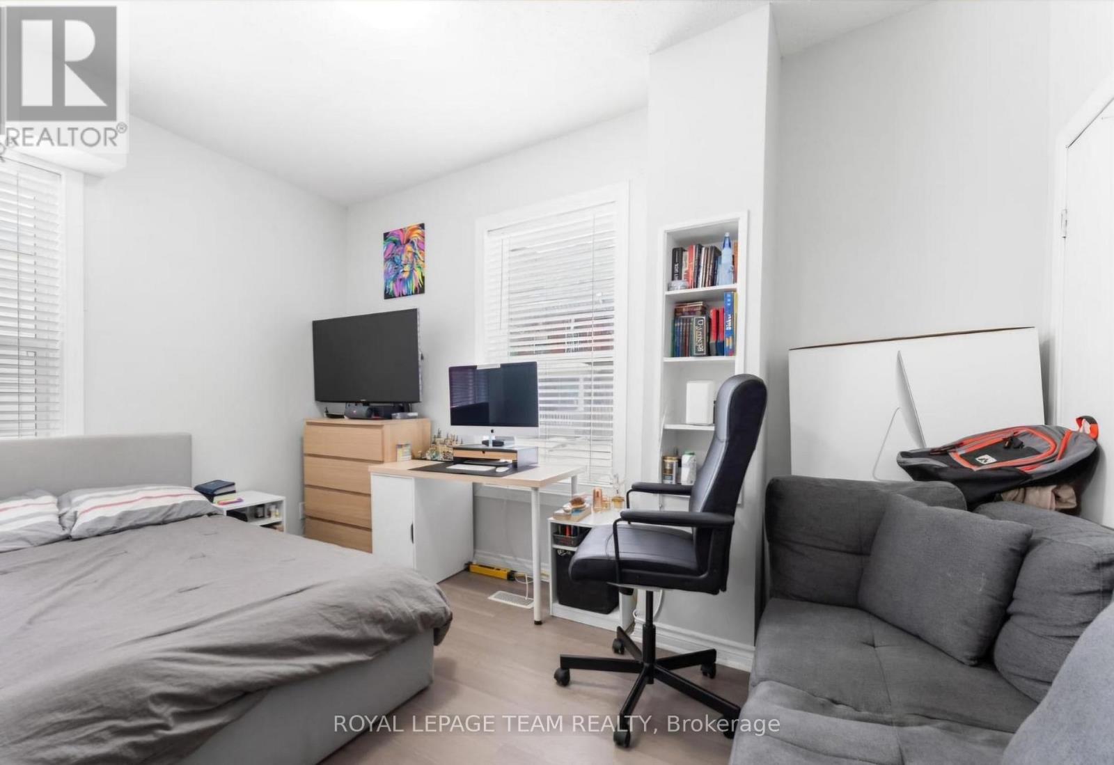 A bedroom with a bed, desk, and chair.
