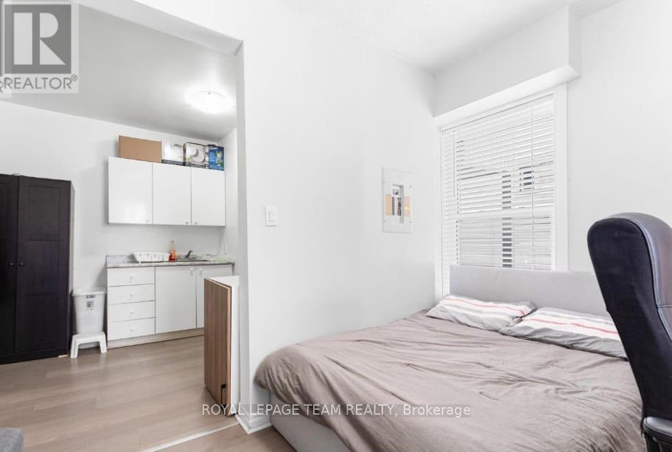 A bedroom with a bed, a desk, and a chair.