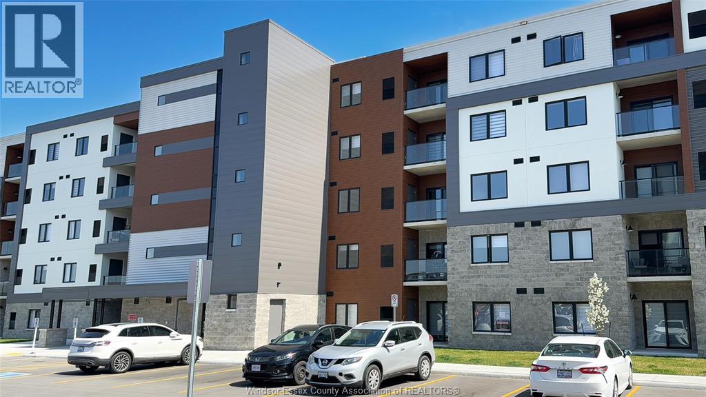 A modern apartment building with cars parked in front.