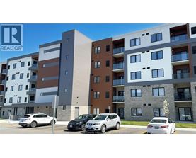 A modern apartment building with cars parked in front.