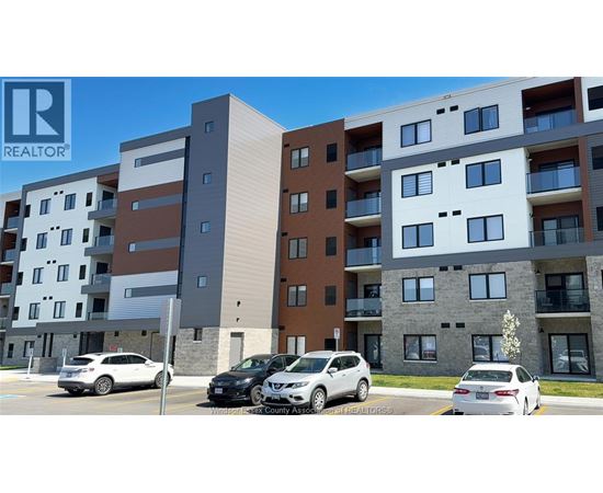 A modern apartment building with cars parked in front.