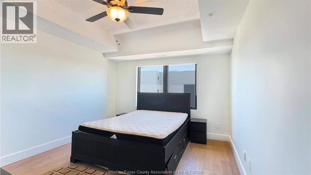 A bedroom with a bed, dresser, and ceiling fan.