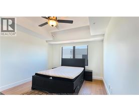 A bedroom with a bed, dresser, and ceiling fan.