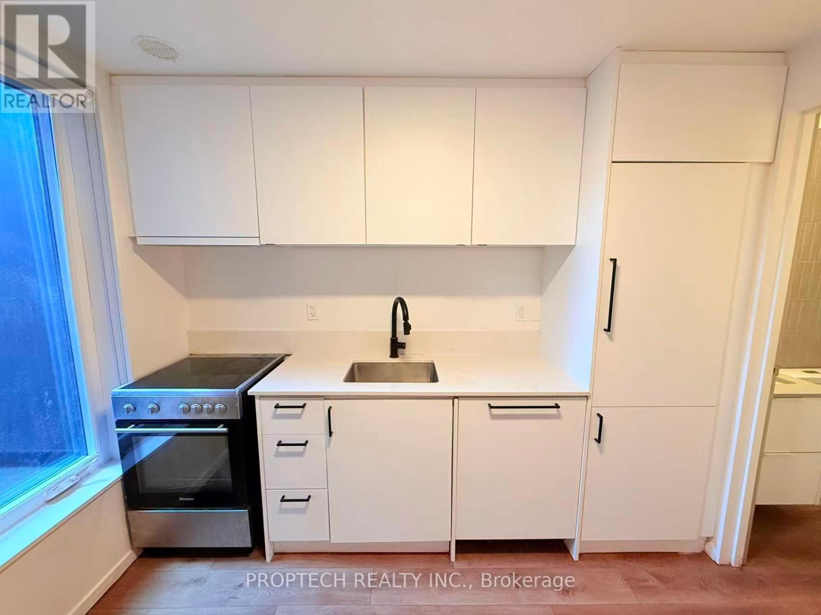 A kitchen with white cabinets and appliances.