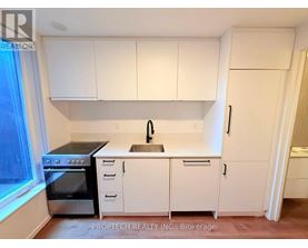A kitchen with white cabinets and appliances.