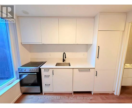 A kitchen with white cabinets and appliances.