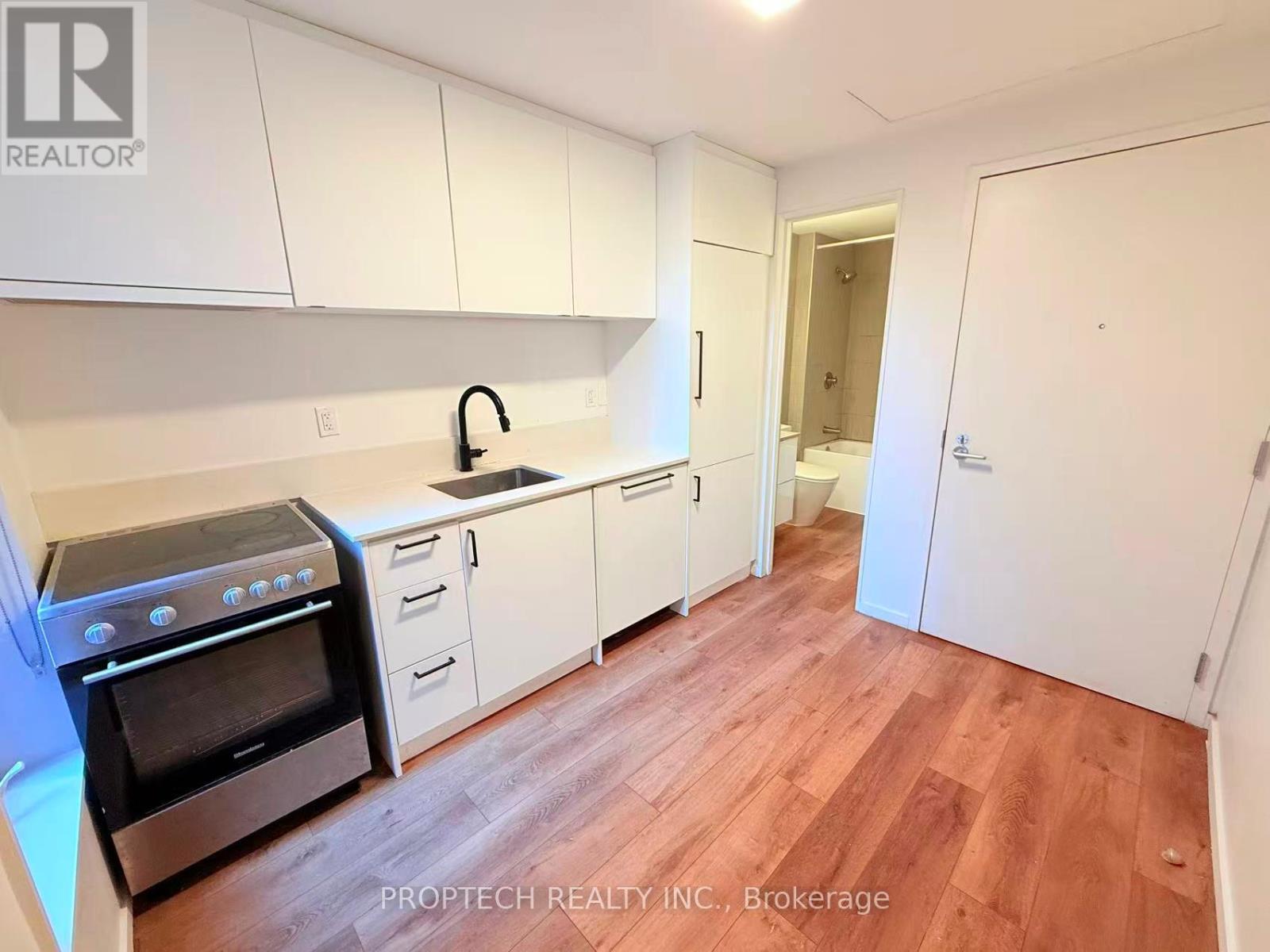 A kitchen with white cabinets and a black stove top oven.